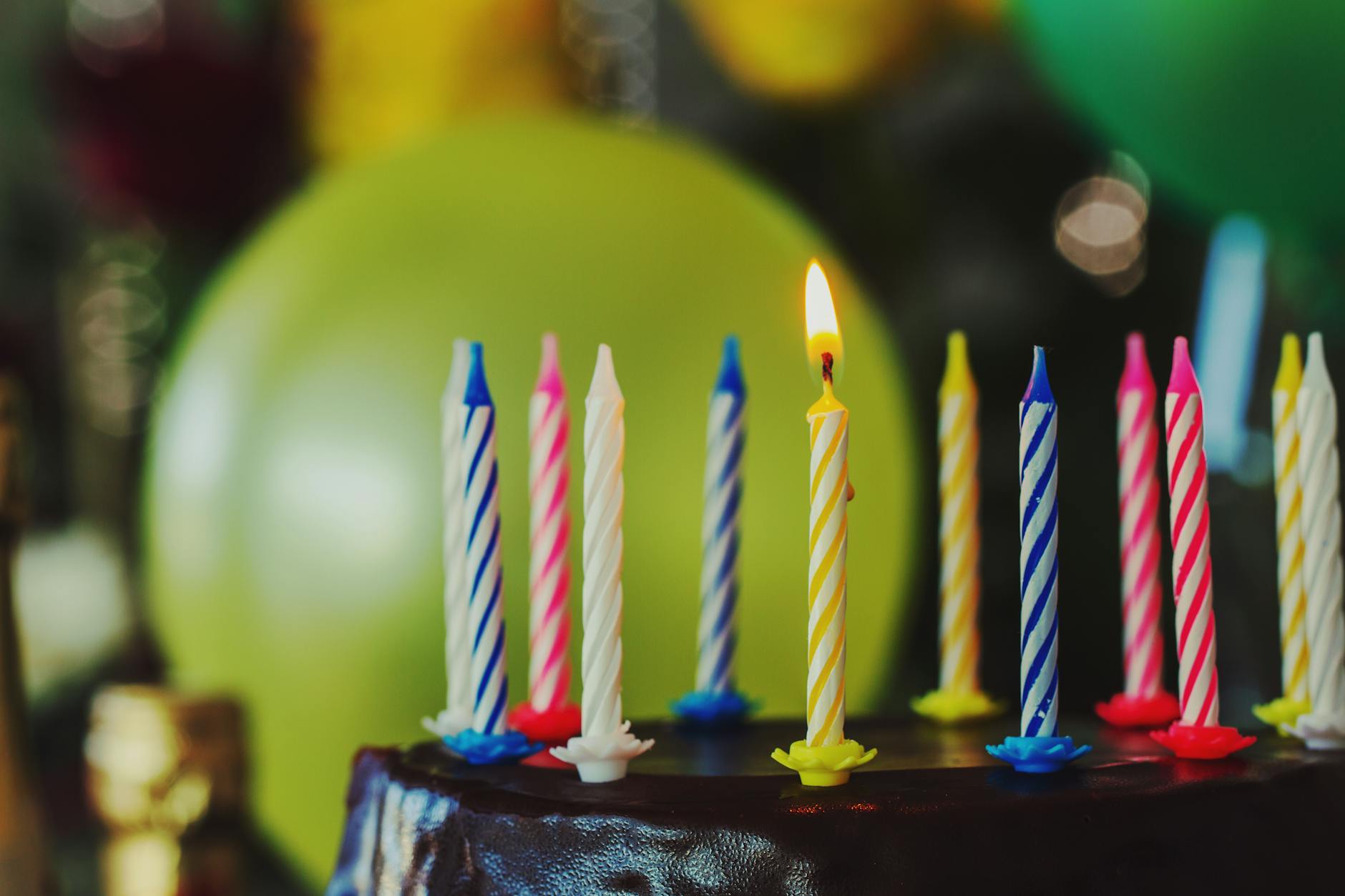 a lighted white and yellow birthday candle
